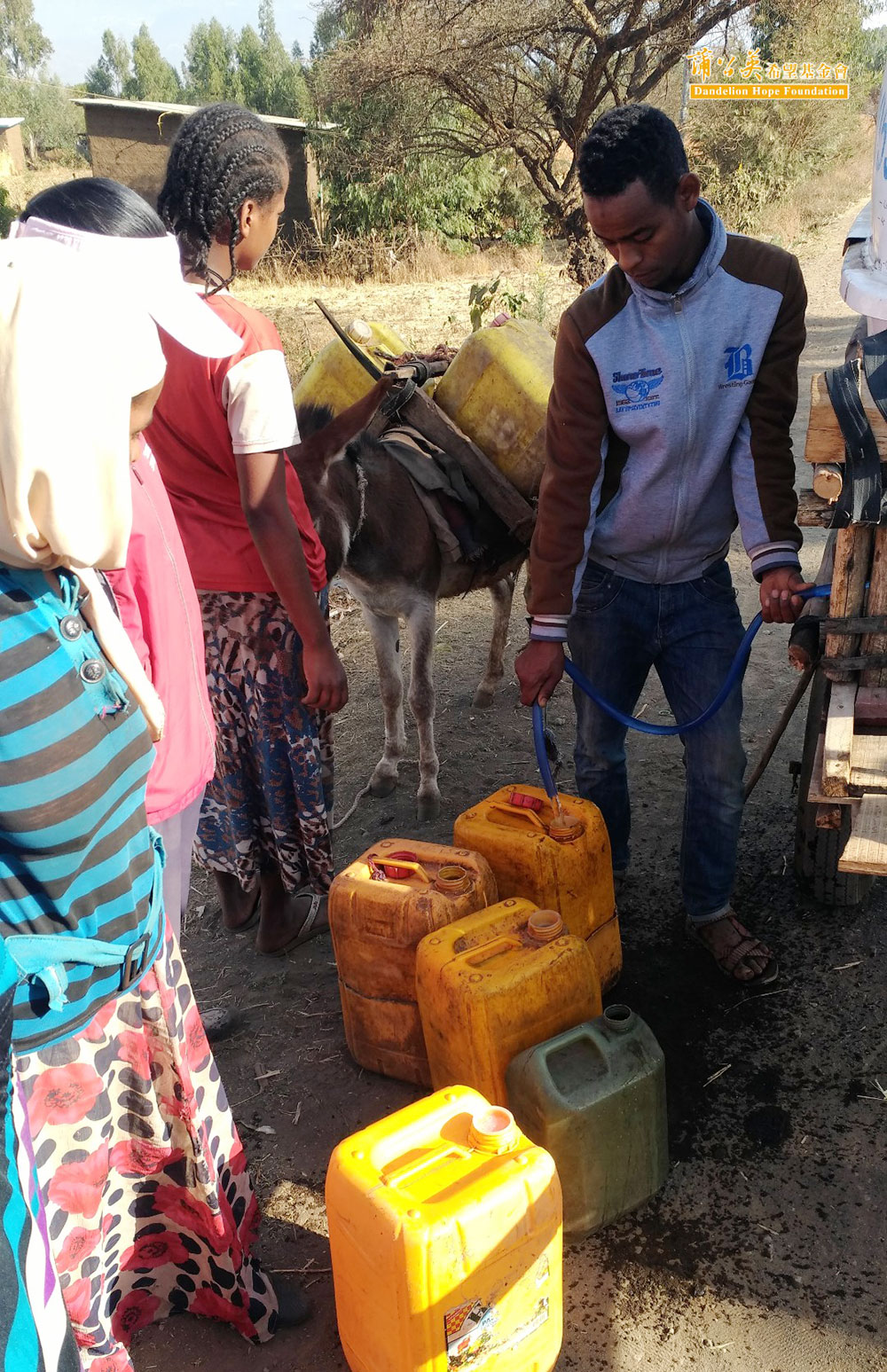 ▲大人小孩排隊取水，裝水的桶子大多是之前物資發送的油桶